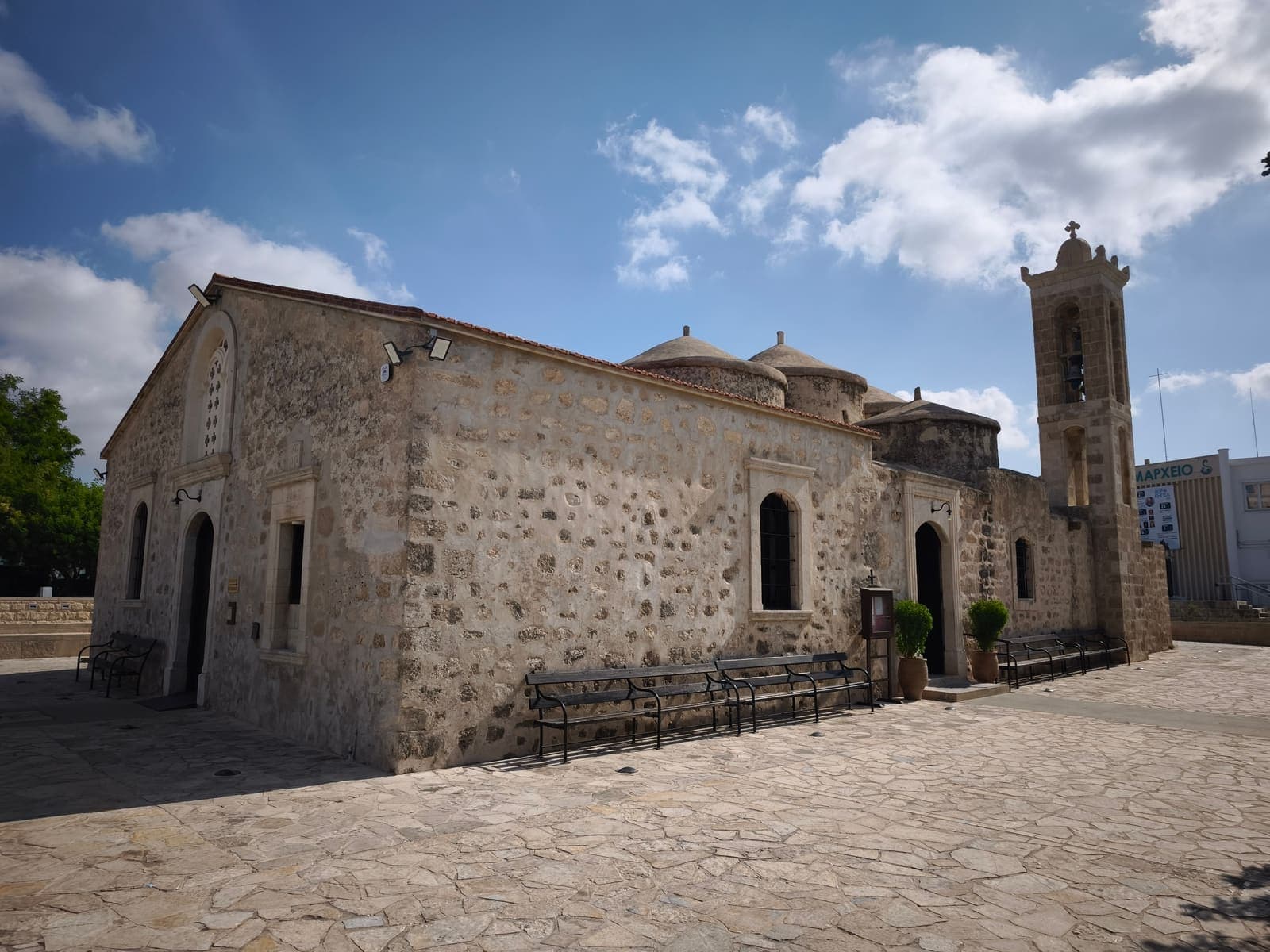 The stone church of Agia Paraskevi in Geroskipou, with its low domes and separate bell tower beside a paved square